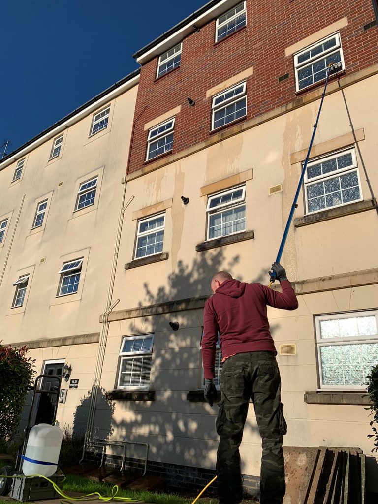 Technician cleaning residential windows in Gloucestershire for a streak-free shine