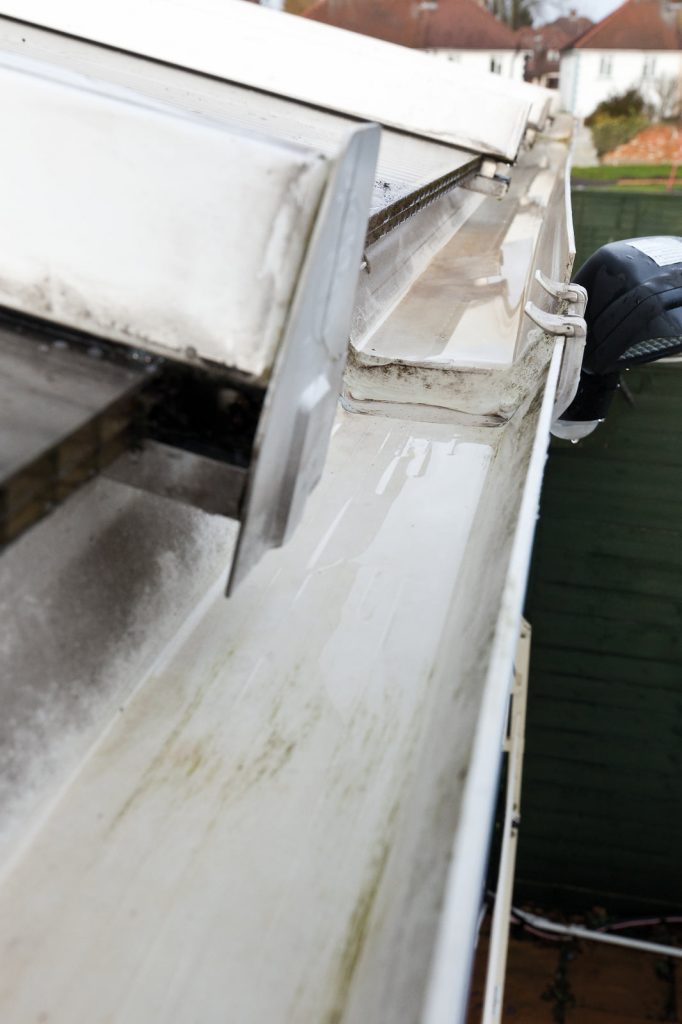 Close-up of a clean white gutter after vacuum debris removal, ensuring clear drainage and protecting homes from leaks and damage.